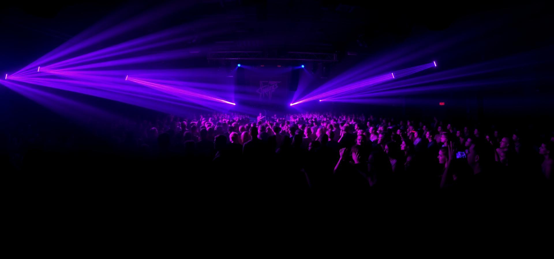 Laser and beam lighting cutting across a full crowd during a live show at the Atlanta venue